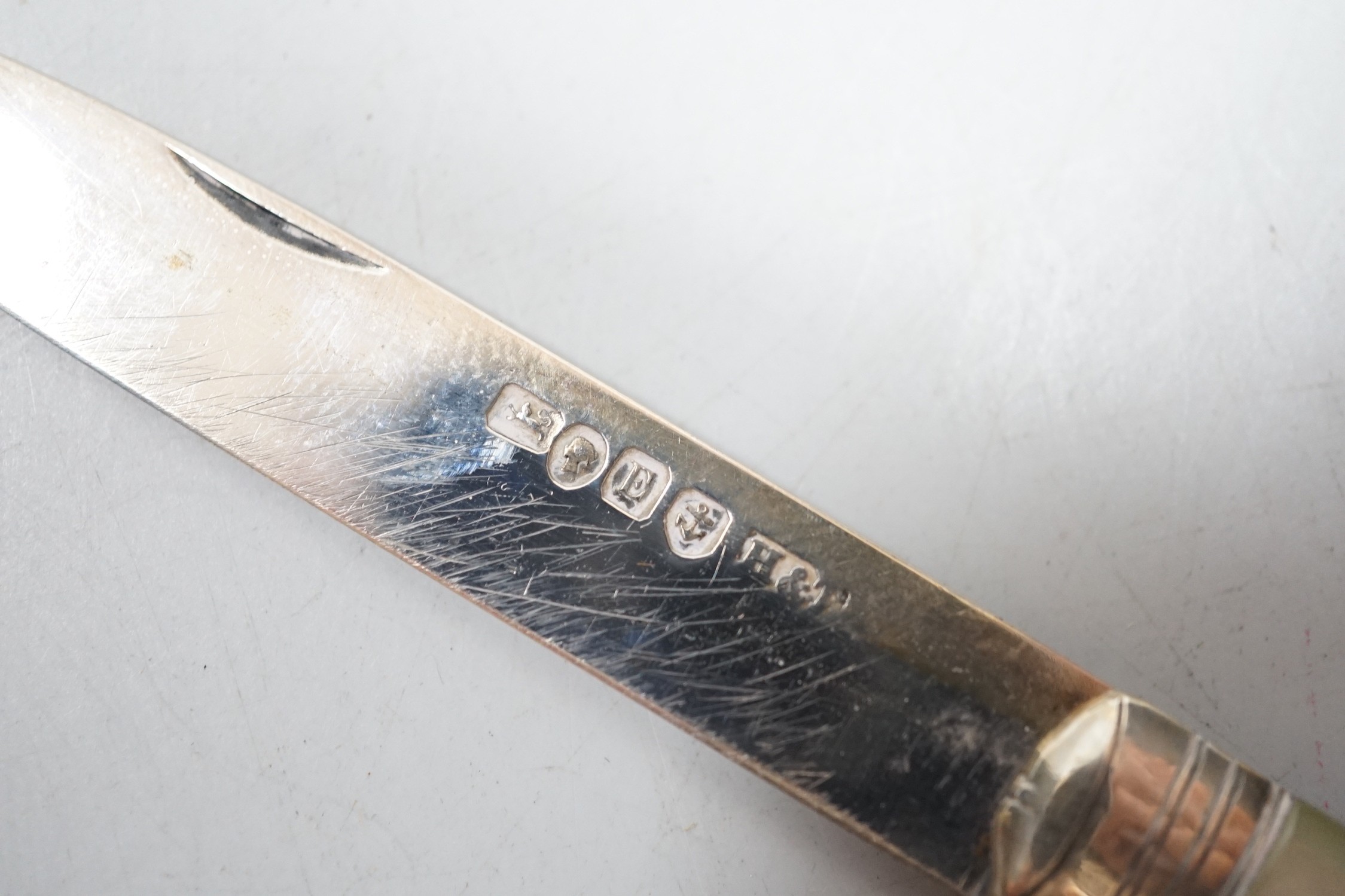 A silver tea strainer, a George III silver 'shovel' caddy spoon, London, 1811, a mother of pearl handled silver fruit knife and George IV silver game skewer, London, 1825, 14.7cm.